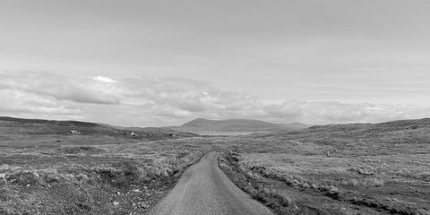 A road on Clare Island looking across Clew Bay to Croagh Patrick on the mainland in black and white.