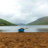 A single blue boat sits on sand in the rain at Lough Nafooey in County Galway. Lough Nafooey is a rectangular shaped glacial lake on the border of County Mayo and County Galway.