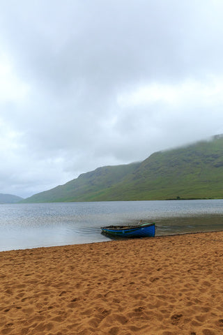 My personal favourite from this series of pictures. Calm. A single blue boats on the red sand in the rain at Lough Nafooey in County Galway. Looking towards the Mayo border.  Lough Nafooey is a rectangular shaped glacial lake on the border of County Mayo and County Galway.