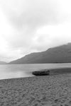 Calm. A single boat on the sand in the rain at Lough Nafooey in County Galway. Looking towards the Mayo border.  Lough Nafooey is a rectangular shaped glacial lake on the border of County Mayo and County Galway.