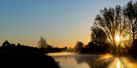 A spectacular sunrise at the ruins at Newtown, Trim with the rising sun reflecting on the River Boyne.