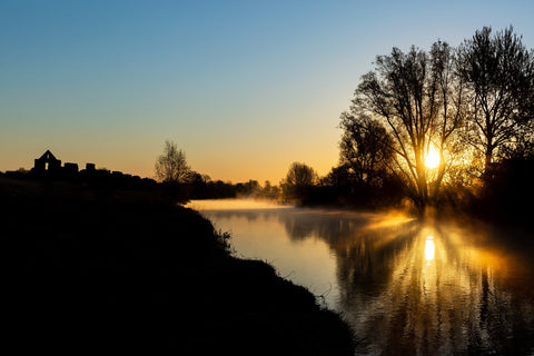 A beautiful sunrise over the River Boyne at the ruins at Newtown, Trim. The sun casting beautiful shadows of the trees over the river.