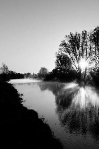 A beautiful sunrise over the River Boyne at the ruins at Newtown, Trim. The sun casting beautiful long shadows of the trees over the river.