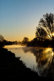 A beautiful sunrise over the River Boyne at the ruins at Newtown, Trim. The sun casting beautiful long shadows of the trees over the river.